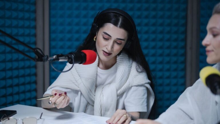Presentatrice met koptelefoon spreekt in een radiostudio in een microfoon
