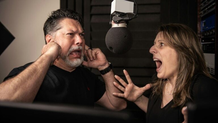 Twee presentatoren discussiëren fel bij een microfoon in een radiostudio